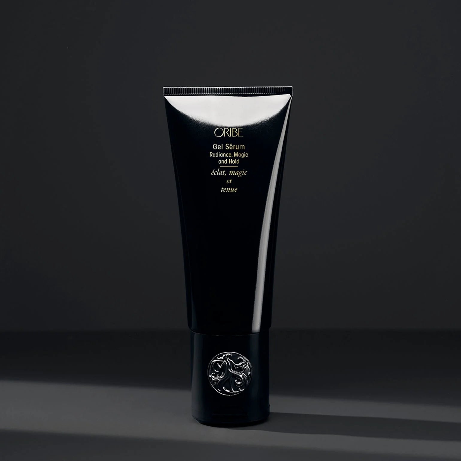Black Oribe hair product tube on a dark background