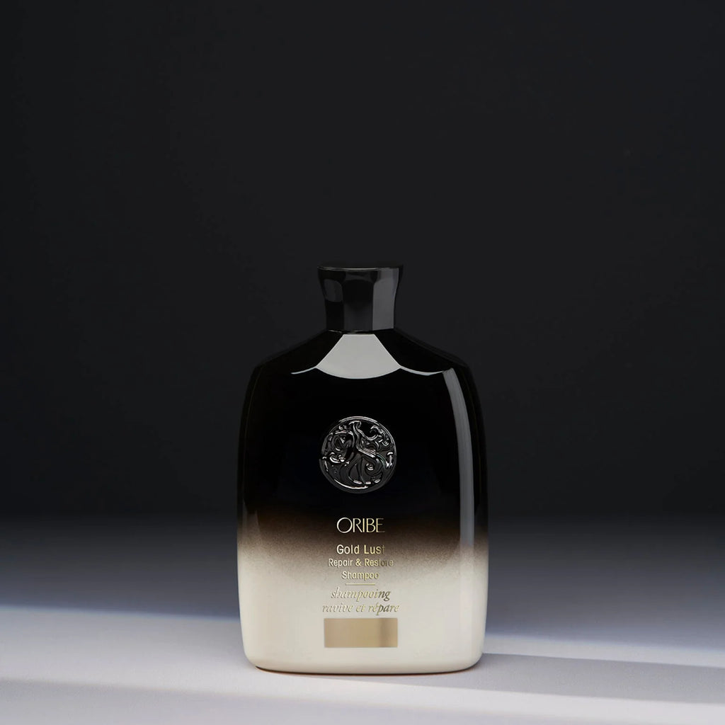 Oribe Gold Lust Shampoo bottle with gradient design on a dark background