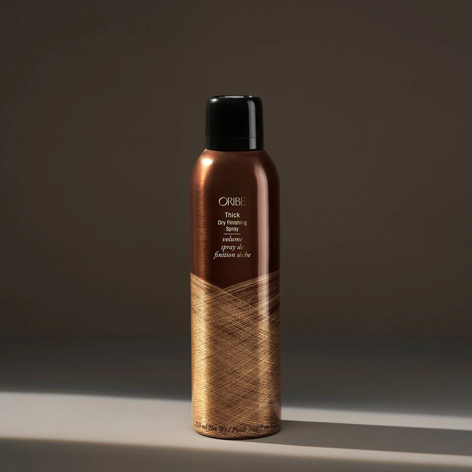 Oribe hair spray bottle on a dark background