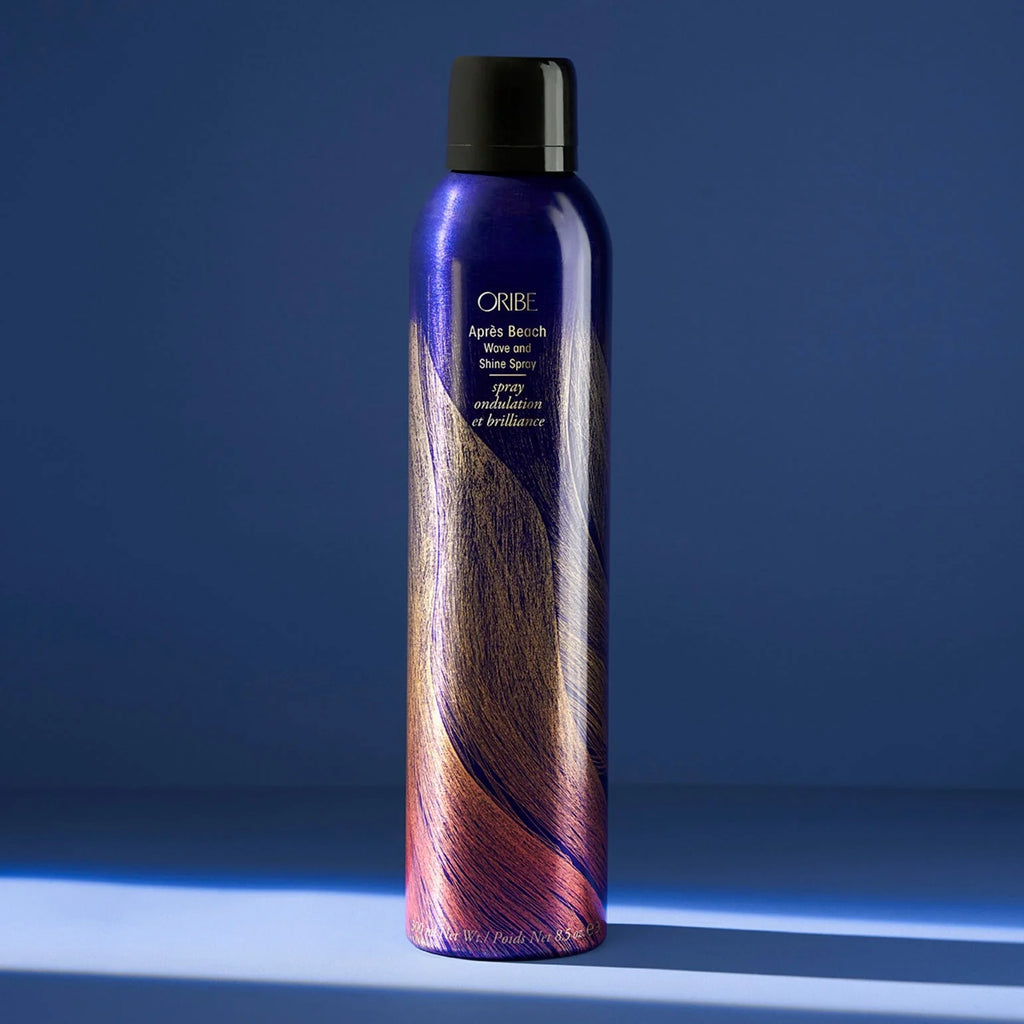 Oribe hair spray bottle with colorful label on a blue background