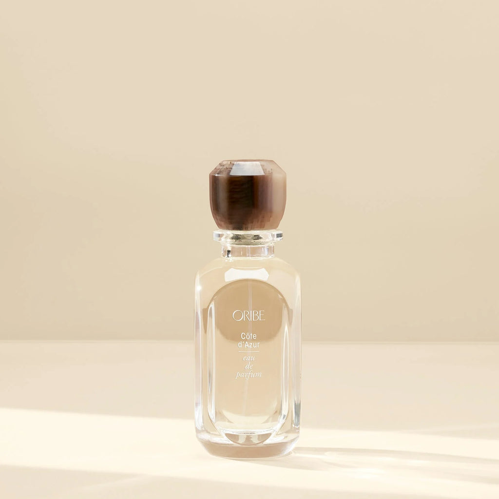 Perfume bottle with wooden cap on a beige background
