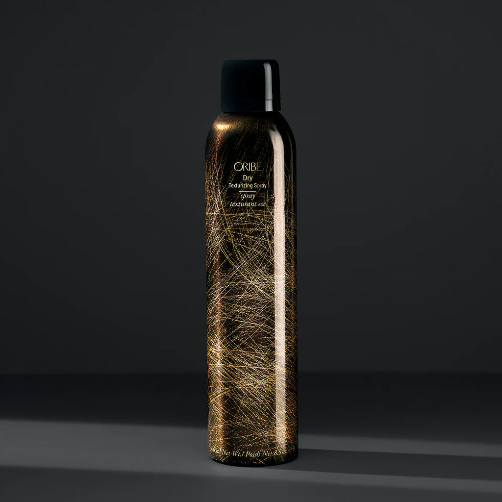 Oribe hair spray bottle on a dark background