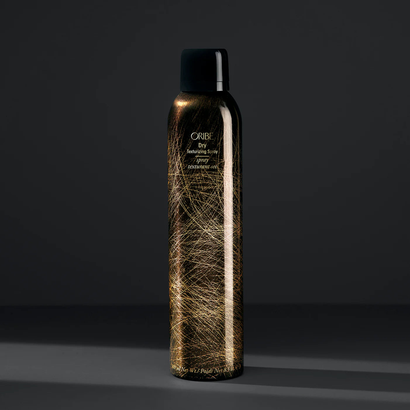 Oribe hair spray bottle on a dark background