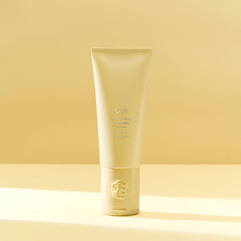 Tube of Oribe haircare product on a beige background