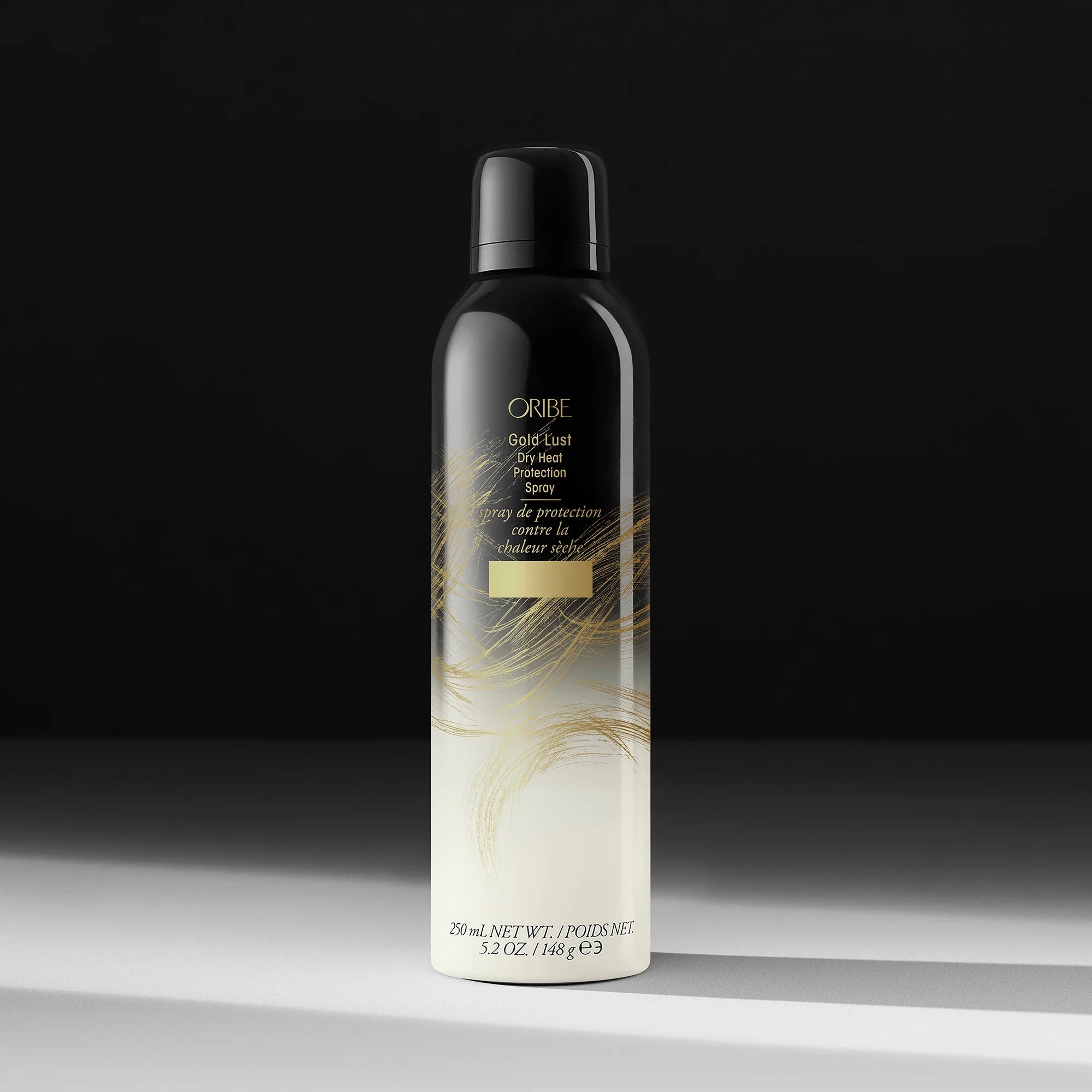 Oribe Gold Lust Dry Texturizing Spray bottle on a dark background