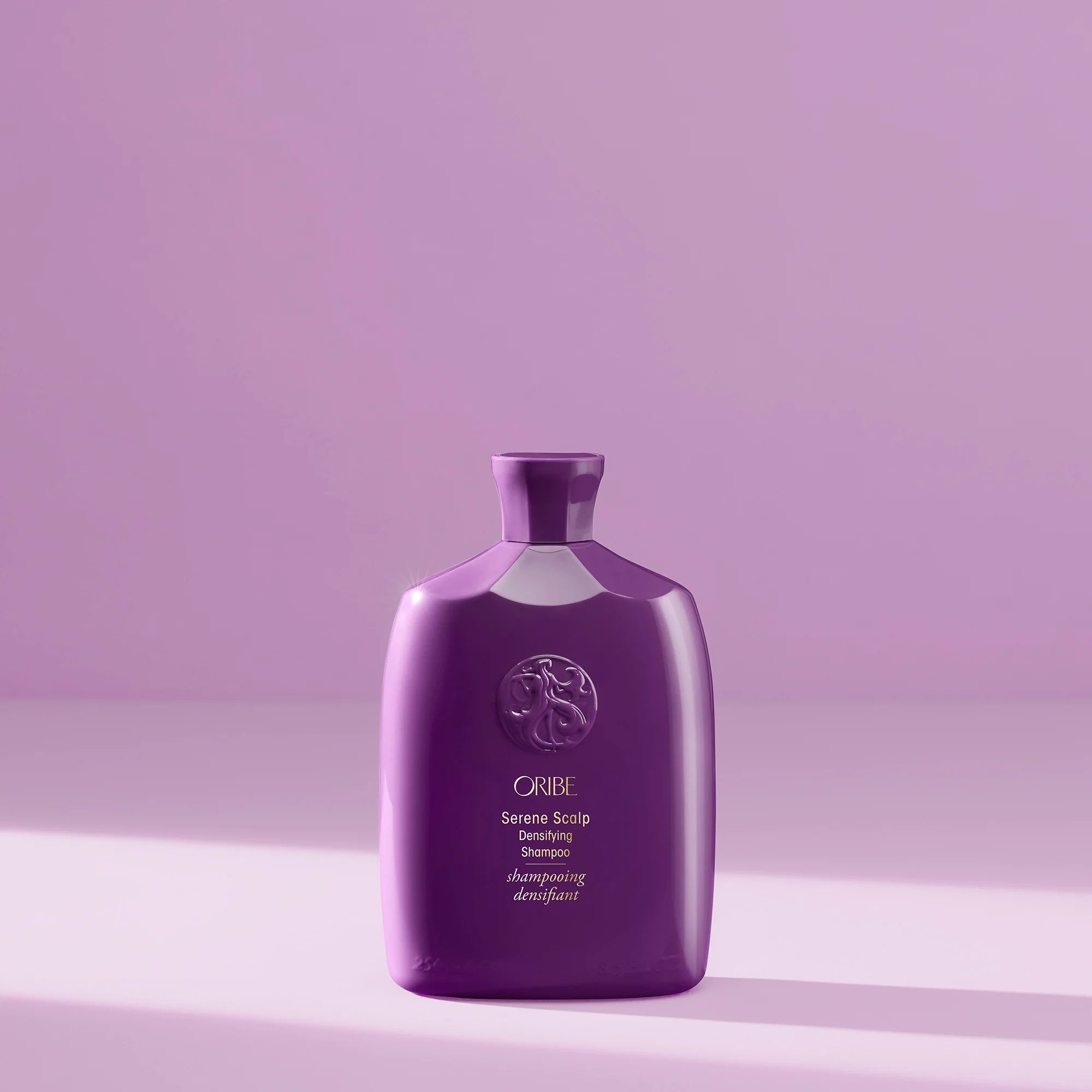Purple bottle of Oribe Shampoo on a matching purple background