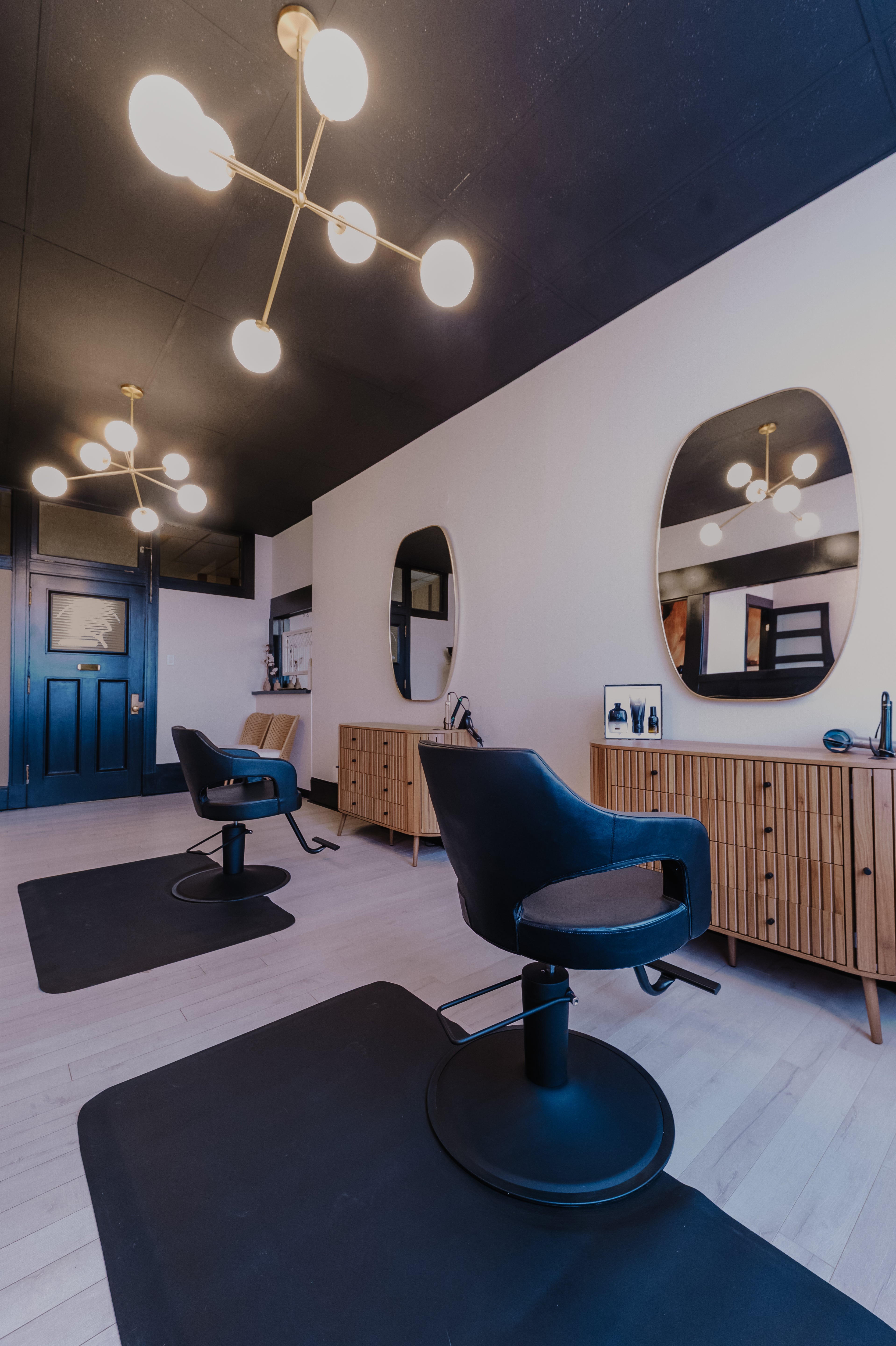 Modern interior with black chairs, wooden cabinets, and stylish lighting fixtures.