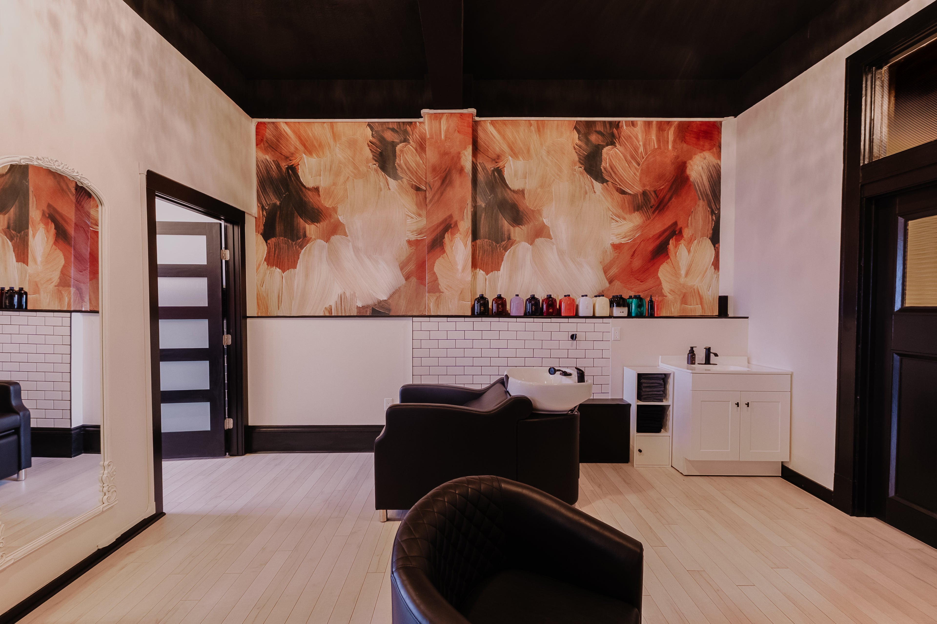 Modern interior design with abstract wall art and black furniture.