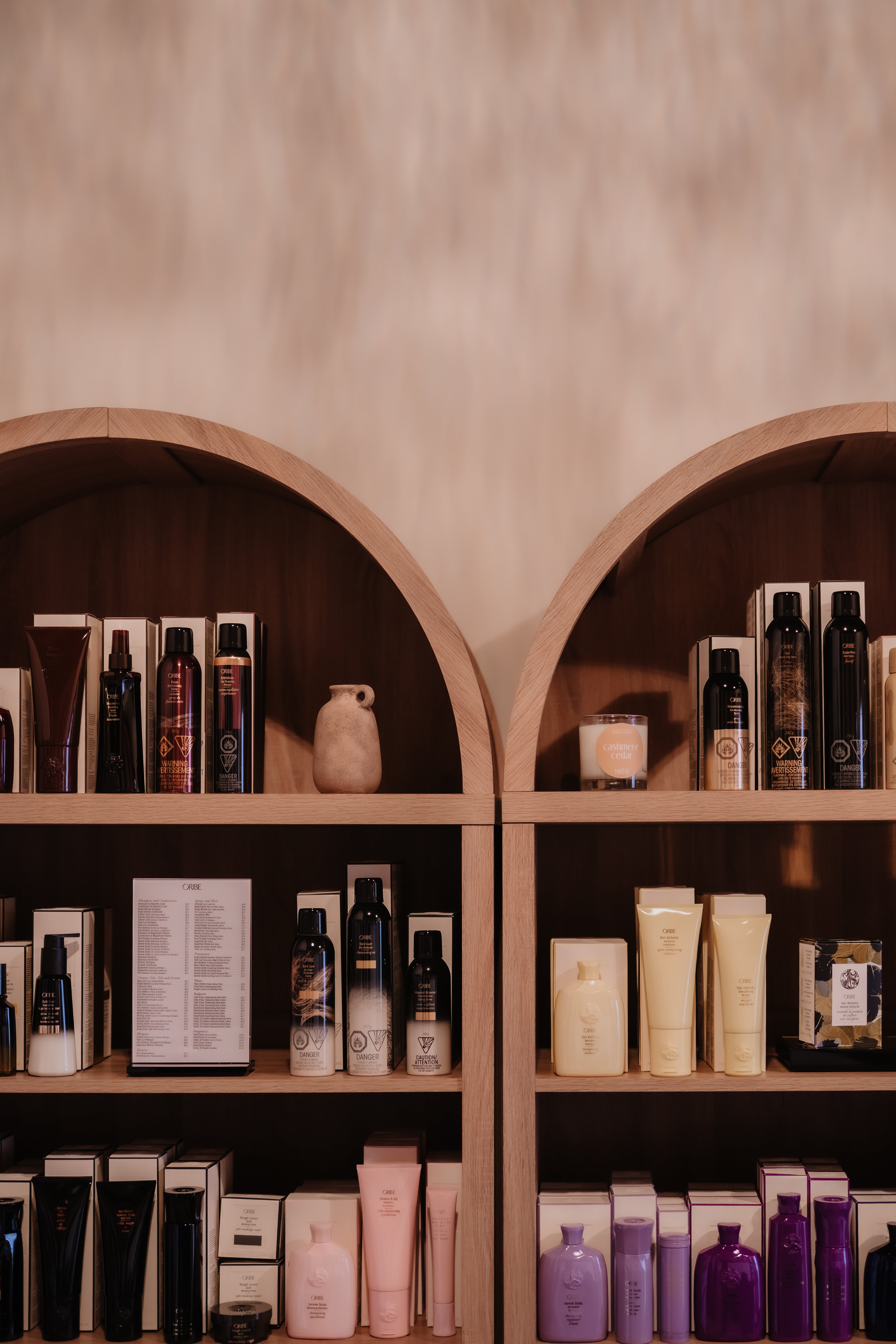 Shelves with various haircare products against a beige wall