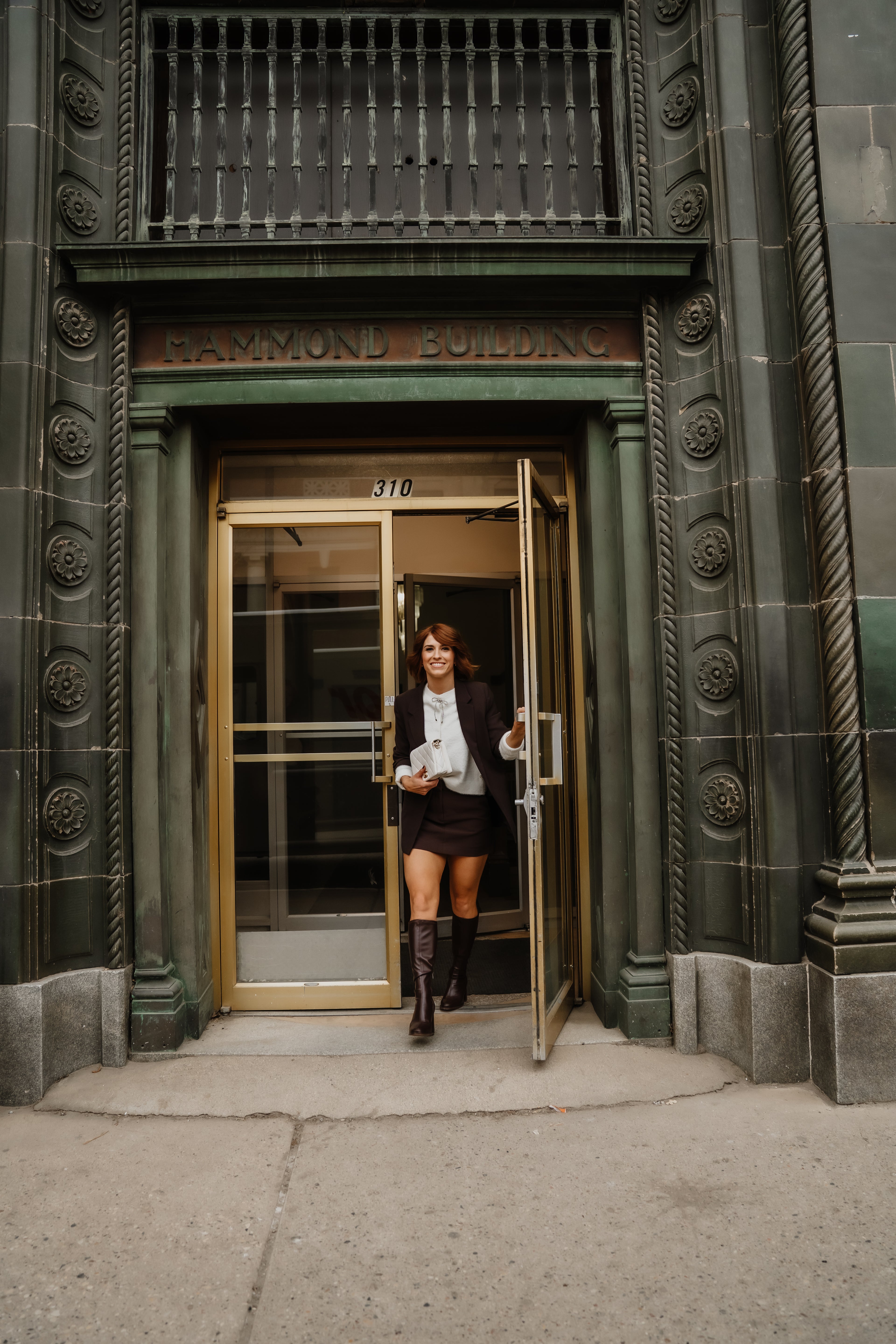 Woman exiting a building with ornate architectural details