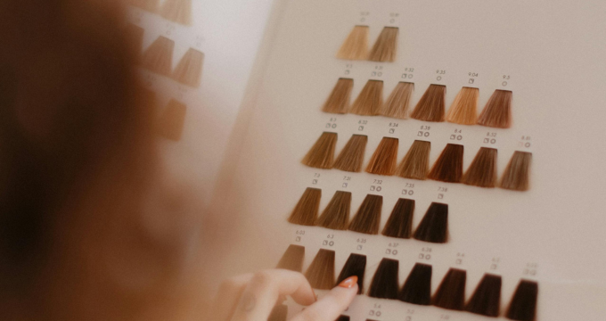 Person selecting hair color swatches from a chart